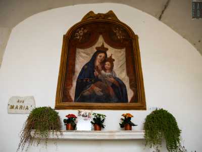 Maria e il bambino incoronati sono raffigurati �esposti� da un elegante sipario rosso aperto da angeli. Lei indossa un manto azzurro sul quale � cucita una stella, rimando all�appellativo di stella maris (�stella del mare�)